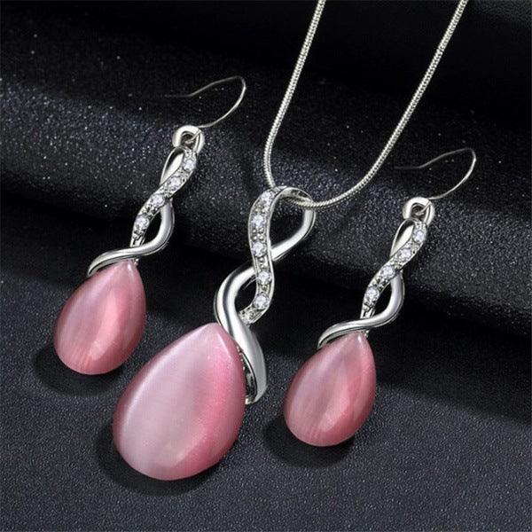 Opal Jewelry set with pink teardrop pendants and silver infinity designs on a dark background